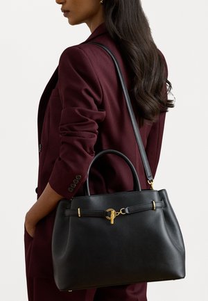 Čierna kožená kabelka so zlatým kovovým hardware, štruktúrovaný tvar, dvojité uši a odnímateľný ramenný popruh.