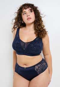 Set di lingerie blu navy con reggiseno ricamato a fiori e pannelli in rete, abbinato a un breve a vita alta, accentuato da dettagli in metallo dorato.
