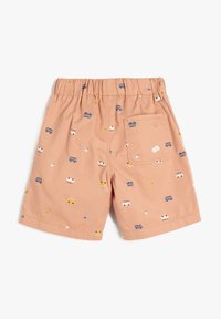 Pantalones cortos color durazno de algodón con cintura elástica. Presenta pequeños patrones de vehículos de colores y acentos en amarillo. Incluye un bolsillo en la parte trasera.