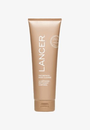 Lancer The Method: Lichaamsreiniging, beige cilindrische tube met witte tekst, bevat een flip-top dop voor doseren. Gladde, matte afwerking.