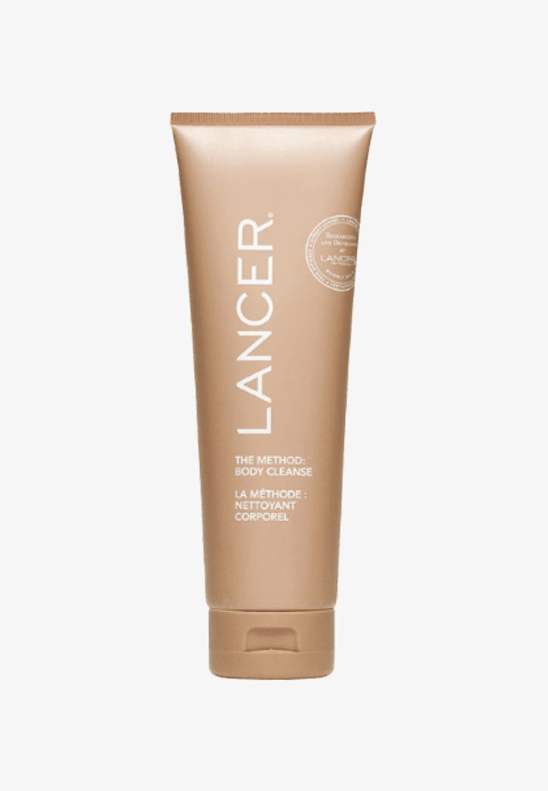 Lancer The Method : Nettoyage du corps, tube cylindrique beige avec texte blanc, contient un capuchon à rabat pour le dosage. Fini lisse et mat.