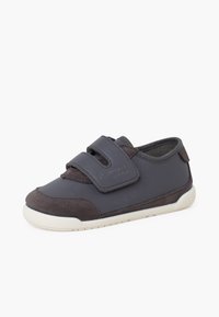 Scarpa sintetica grigia con accenti in suede, presenta due fasce in velcro e una suola in gomma bianca, progettata per comfort e facilità d'uso.