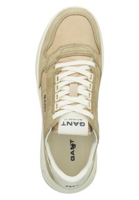 Beige Wildleder- und Stoffsportler mit weißen Schnürsenkeln, gepolstertem Zungenbereich und Markentag. Runde Zehenpartie und strukturierte Sohle. Draufsicht.