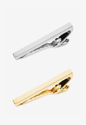 Dva držača za kravate: jedan srebrni i jedan zlatni. Svaki ima elegantan, pravokutan oblik s poliranim završnim slojem i teksturiranim kopčanjem za bolji zahvat.