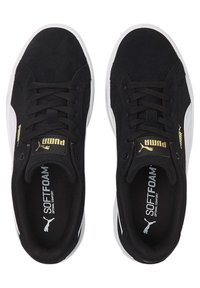 Zapatillas de ante negro con suelas de goma blanca. Las características incluyen cordones negros, un logo dorado en la lengüeta y un interior de espuma suave para mayor comodidad.