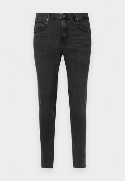 Fekete, karcsúsított szabású farmernadrág elülső gombos és cipzáras záródással, két elülső zsebbel és övhurkokkal, egyszerű fehér háttéren bemutatva.