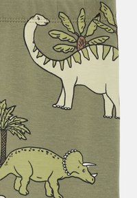 Tessuto verde oliva con illustrazioni di dinosauri, tra cui un brontosauro e un triceratopo, con accenti di palme e arte lineare semplice.