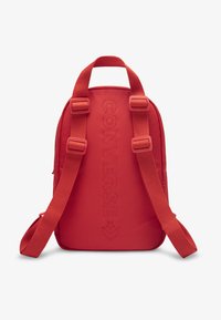 Κόκκινο σακίδιο πλάτης από πολυεστέρα με επενδυμένους ιμάντες, διακοσμημένο με υφασμένη λογότυπο "CONVERSE" στο μπροστινό μέρος και μινιμαλιστικό σχέδιο.