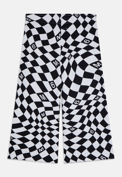 Czarno-białe spodnie w wavy szachownicowy wzór, z rozsianymi znakami "M" i "6" na tkaninie.
