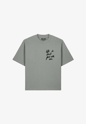 Lichtgrijs T-shirt met korte mouwen en zwarte cursieve tekst op de linkerborst met de tekst "life is short flirt with me," en een merklabel van Mira Paris aan de binnenkant van de kraag.