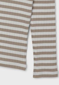 Leggings rayés en beige et blanc, avec une texture côtelée et des ourlets cousus. Le design comprend des rayures horizontales de largeurs variées.