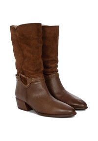 Botas de ante marrón con un diseño despeinado, puntas puntiagudas, secciones inferiores de cuero texturizado y acentos de hardware trenzado. Tacón cuadrado.