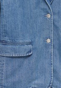 Light blue denim jacket featuring visible stitching, a front pocket, and silver snap buttons along the closure. Smooth texture.