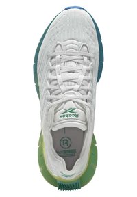 Baskets blanches avec un dessus en maille texturée, accents de semelle verts et bleus, et logo Reebok sur la languette et la semelle intérieure.