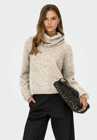 Maglione oversize color beige chiaro con collo a cowl, texture a maglia, orlo a coste, abbinato a una borsa a tracolla con stampa leopardata nera.
