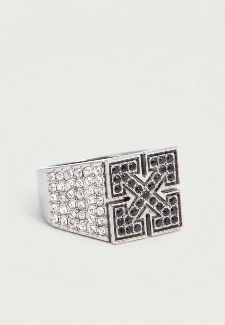 Bague en argent à large anneau, ornée de pierres transparentes sur un côté et d’un motif géométrique d’étoile noire sur le devant.
