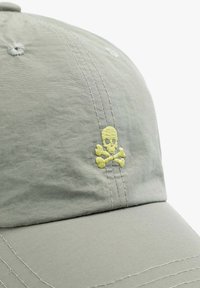 Graue Baseballmütze aus leichtem Stoff, mit gelber Totenkopf- und gekreuzten Knochen-Stickerei auf der Vorderseite. Dezente Steppdetails.