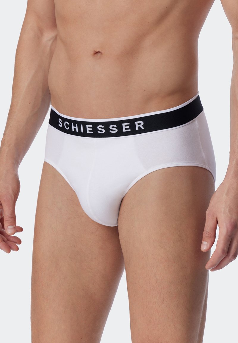 Weiße Unterhosen im Brief-Stil mit einem schwarzen elastischen Bund, auf dem der Markenname "SCHIESSER" deutlich angezeigt wird. Glatte Baumwolltextur.