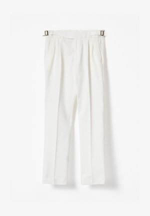 Pantalones blancos de cintura alta con pliegues delanteros, bolsillos laterales y hebillas laterales ajustables, colgados contra un fondo blanco.
