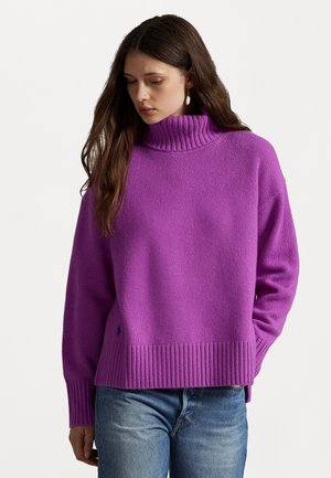 Maglione a maglia viola con un collo a coste alto e orlo a coste. Tessuto morbido, vestibilità rilassata, con un piccolo logo dettagliato sul lato.
