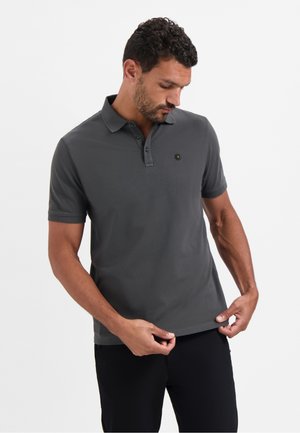 Grijze polo gemaakt van soepel katoen, met een kraag, een drie-knopen sluiting met groene knopen en een klein logo op de borst.