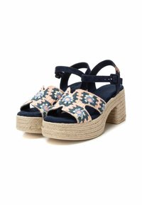 Sandalias de plataforma de ante azul con suela de yute trenzado, adornadas con bordados florales en rosa y verde en las correas. Hebilla ajustable en el tobillo.