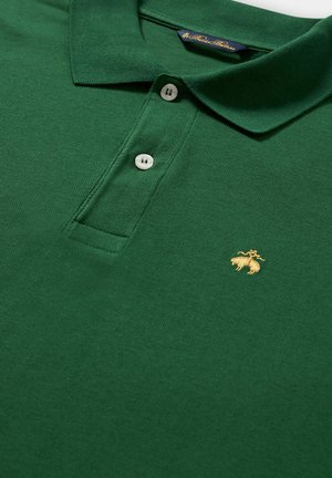 Zelená polo tričko z bavlněné látky s límečkem, třemi bílými knoflíky a malým vyšitým zlatým logem.