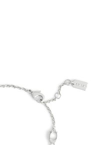 Bracelet en chaîne argentée avec un fermoir à homard, des maillons ovales et une étiquette gravée "Coach". Design élégant et minimaliste.