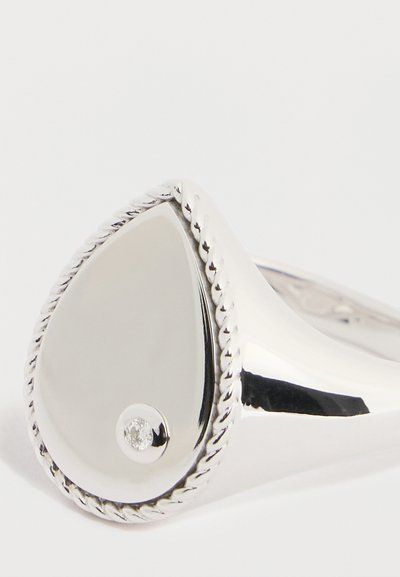 Hõberõngas pisarakuju, läikiva pinnaga, serva ümber keerutatud nööriga detailide ja väikese teemantaktsendiga.