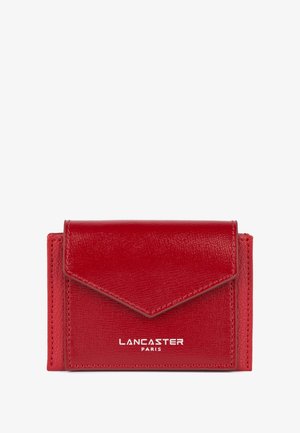 Portefeuille en cuir rouge avec une finition texturée, présentant une fermeture à rabat triangulaire, un logo "Lancaster Paris" en relief et une forme rectangulaire compacte.