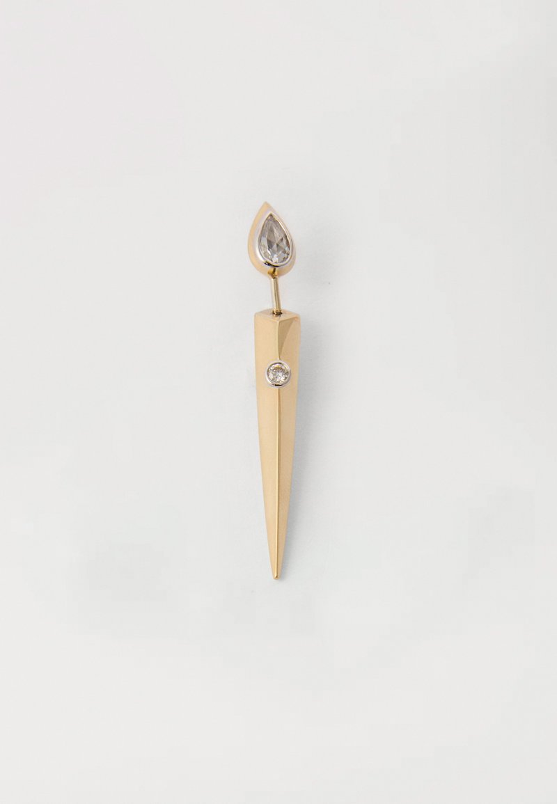 Broche em tom dourado com uma forma pontiaguda e alongada. Apresenta um cristal em forma de gota na parte superior e um destaque em cristal circular perto da base.