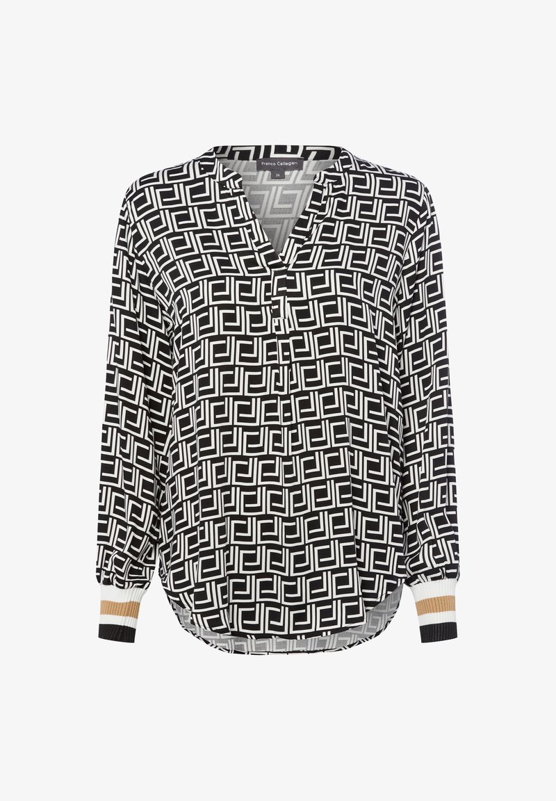 Blusa a maniche lunghe bianco e nero con motivo geometrico, colletto a doppia apertura e polsini a costine con strisce bianche, beige e nere.