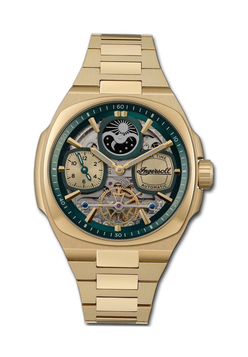 Goudkleurig automatisch horloge met een groene bezel, een skeleton wijzerplaat die de tandwielen toont, twee subwijzers en een gestructureerde gouden armband.
