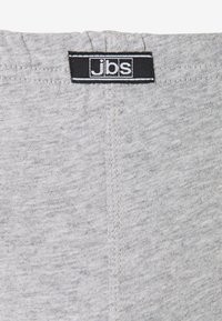 Graue Shorts mit elastischem Bund, aus weichem, strukturiertem Stoff. Mit einem schwarzen Etikett mit weißem Text und minimalen Nähten an den Rändern.