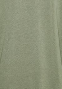 Tejido de punto verde claro con una textura suave, que presenta un patrón uniforme y un acabado liso. Ideal para ropa casual o para superponer.