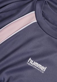 Lila sporttröja med rund hals, rosa och vita diagonala ränder samt "hummel PERFORMANCE"-logotyp i vitt på framsidan.