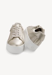 Sneakers platform in beige metallico con una parte anteriore liscia, una parte posteriore a motivo testurizzato e suole in gomma bianca. Presentano chiusure con lacci e cerniera.