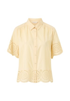 Light yellow short-sleeve button-up blouse with collar and eyelet cutout floral patterns on sleeves and hem.