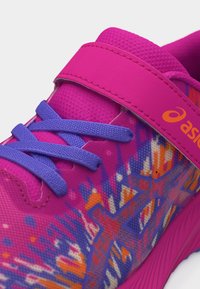 Ροζ και μοβ αθλητικό παπούτσι με μπλε κορδόνια, πορτοκαλί λογότυπο ASICS, πολύχρωμα γεωμετρικά σχέδια και ροζ λουράκι με βέλκρο.