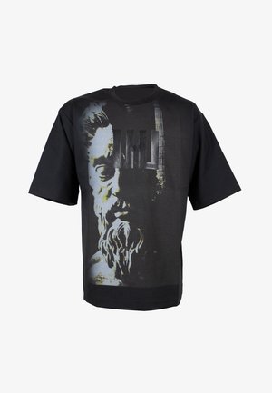 T-shirt nera in cotone con una grafica di una figura barbuta e il testo "HOMME" in un design audace. Maniche corte e vestibilità ampia.