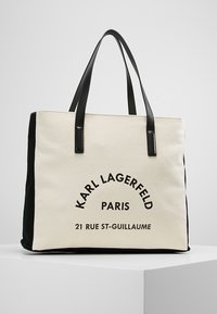 Torba płócienna z czarnymi akcentami, z wyraźnym napisem: "KARL LAGERFELD PARIS 21 RUE ST-GUILLAUME." Dwie mocne czarne uchwyty.