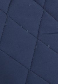 Marineblauw gevoerd stof met een ruitpatroon en verhoogde naden. De textuur lijkt zacht en glad, geschikt voor verschillende toepassingen.