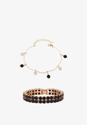 Armbanden met goudkleurige tint en zwarte en heldere edelsteentjes; de ene is een fijn kettinkje met hangende bedeltjes, de andere een brede band met twee rijen stenen.