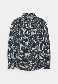 Knäppt jacka i marinblått med abstrakta svartvita geometriska mönster. Har tryckknappar och en klassisk kragsdesign.