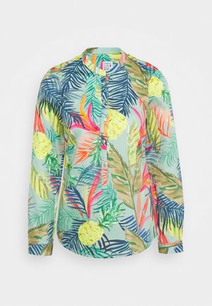 Pitkähihainen napillinen paita, jossa on eläväinen trooppisten lehtien ja ananaksen kuvio vihreän, sinisen, vaaleanpunaisen, oranssin ja keltaisen sävyissä.
