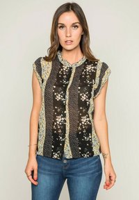 Blouse noire à manches courtes avec des motifs floraux et des accents jaunes, dotée d'un design à boutons sur le devant et d'un col en dentelle.