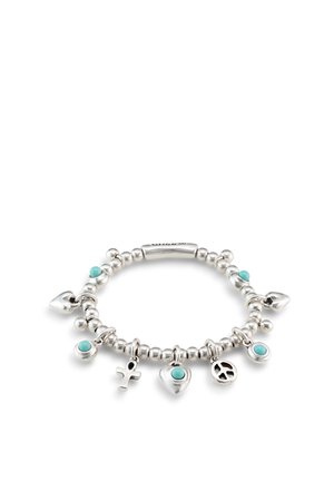 Bracelet en argent avec pierres turquoise, comprenant des breloques en forme de cœur, croix, symbole de paix et perles rondes sur fond blanc.