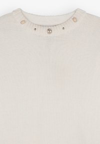 Cremefarvet strikket sweater med ribkantet hals, udstyret med dekorative knapper og ædelstene ved kraven. Blød, struktureret overflade.