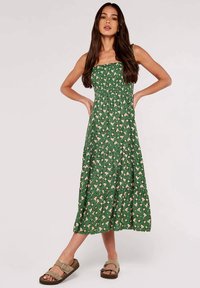 Grünes, blumiges Maxikleid mit gerafftem Oberteil, Trägern und gestuftem Rock. Verziert mit kleinen rosa Blumen und einer weichen Stofftextur.