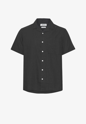 Chemise noire à manches courtes en tissu texturé avec un col, une poche avant et des boutons blancs centrés. L'ourlet présente une légère courbe.